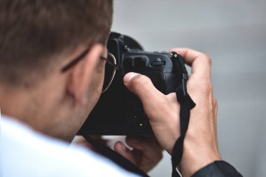 Yakın erkek elleri profesyonel kamera tutun ve bir fotoğraf yapmak.