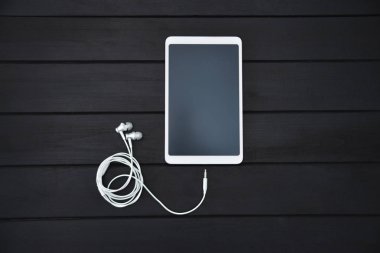 teknoloji, müzik, gadget ve nesne kavramı - beyaz akıllı telefon yakın, tablet pc ve ahşap arka plan üzerinde kulaklık. ücretsiz copyspace