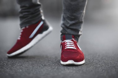 Spor kırmızı spor ayakkabılar asfalt üzerinde yakın çekim. Alt açıdan bacaklar ve ayakkabılar.