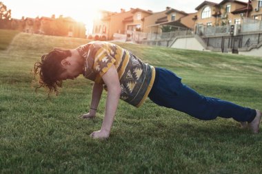 Spor. Atlet parkta gün batımında Push-up yapıyor. sıska adam egzersiz ve uygun almak için çalışıyor. sert eğitim
