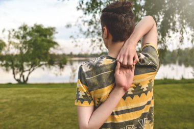 Adam egzersiz yapıyor yoga genç Fitness adam açık performans. Backview. ellerini arkasına bir araya koyar