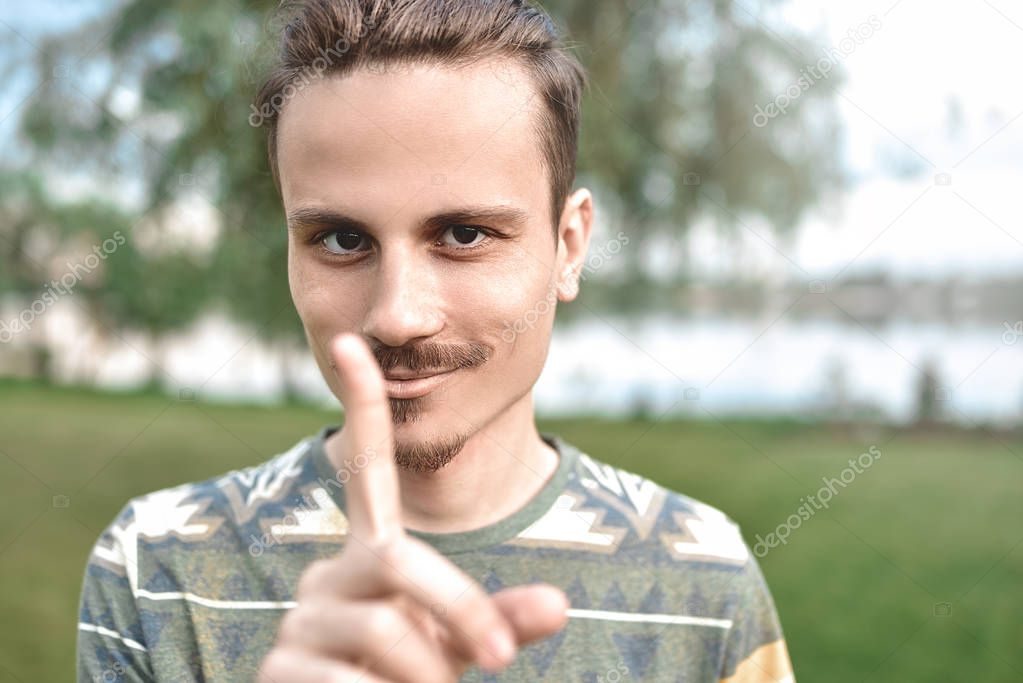 a guy with a sly expression on his face, shows a finger gesture, says do not try to deceive me