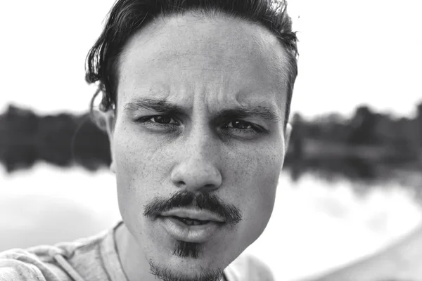 Retrato de un tipo con estilo brutal mirando agresivamente a la cámara. foto en blanco y negro. foto selfie — Foto de Stock