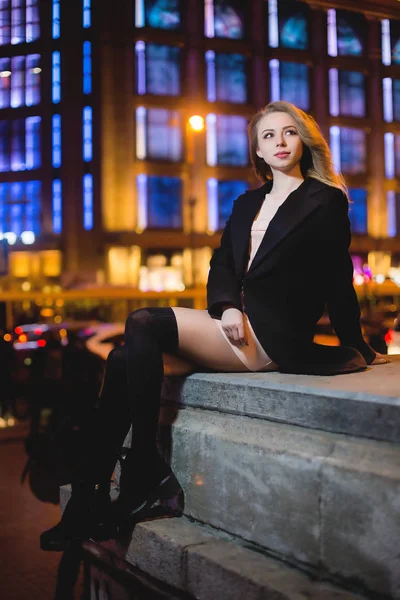 Retrato de Hermosa joven en negro sobre un fondo de una ciudad nocturna — Foto de Stock