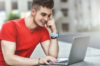 Düşünceli genç beyaz adam internette sohbet etmek için laptop kullanıyor..