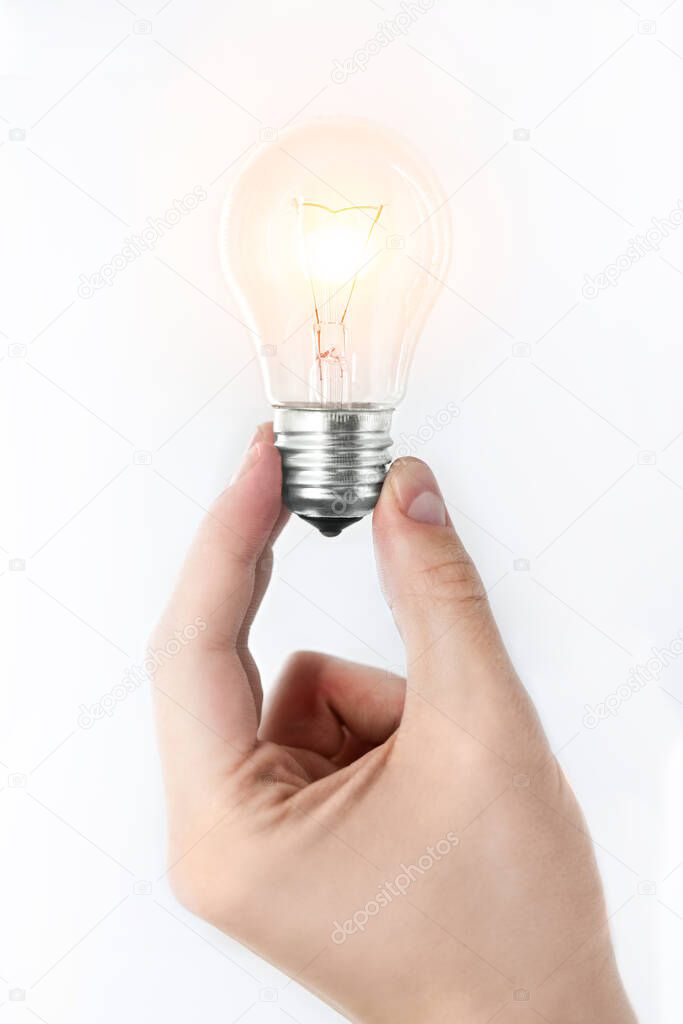 A man's hand holding a burning light bulb on a white background