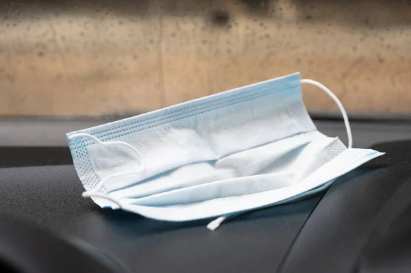 Medical face mask placed on the car console. concept To protect against the influenza Coronavirus (Covid-19) in car.