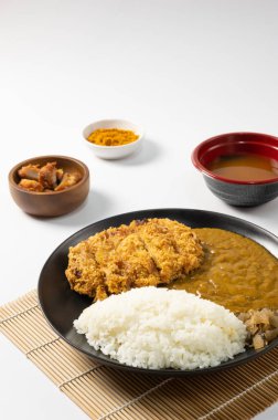 Tonkatsu Curry Rice (Japon usulü kızarmış domuz pirzolası ve köri pilavı) kareage (Japon usulü kızarmış tavuk) ile servis edilir. beyaz arkaplan. 