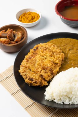 Tonkatsu Curry Rice (Japon usulü kızarmış domuz pirzolası ve köri pilavı) kareage (Japon usulü kızarmış tavuk) ile servis edilir. beyaz arkaplan. 