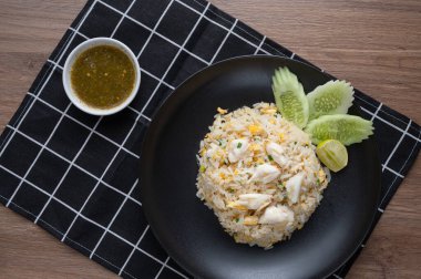 Yengeç etli, yumurtalı, sarımsaklı, salatalıklı, limonlu leziz pilav. Khao Pad Poop adında Tayland yemeği. Ahşap arka planda üst manzara. düz yat.
