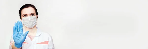 Tıbbi maskeli ve mavi eldivenli kız Coronavirus 'u durdurmak için el ele durduğunu gösteriyor. Hayatımızda koronavirüs yok. Uzayı kopyala, afiş