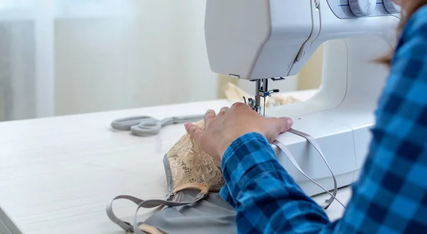 Mavi kareli gömlekli neşeli bir terzi atölyesinde çalışıyor. Yakın plan, Lacy 'nin kadın iç çamaşırlarını dikiyor..