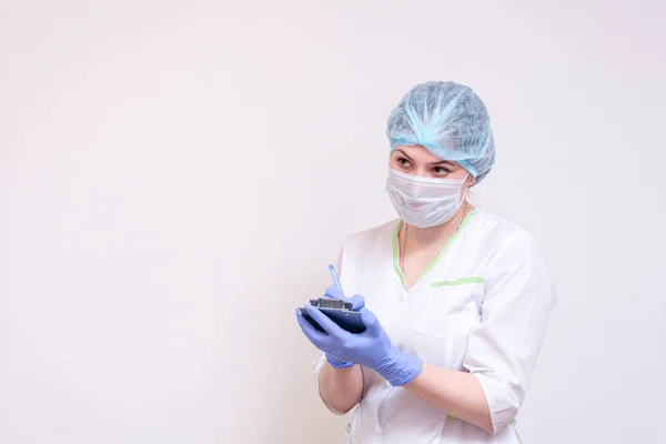 A young female doctor makes notes on a tablet — Stock Photo, Image