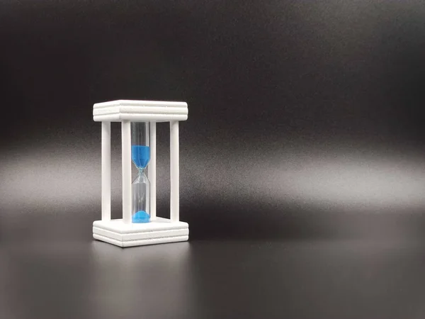 Clessidra bianca con sabbia blu, che mostra l'ultimo secondo o minuto. il concetto di passare del tempo. Con spazio per la copia — Foto Stock