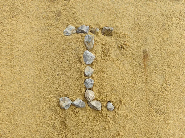 The Roman numeral 1 is laid out with stones on the river sand. — Stock Photo, Image