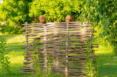 Yeşil ormana karşı tepesinde kil kaplar olan köy çiti.