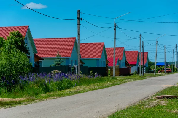 Kırsal alan, yol boyunca kırmızı çatıları olan özdeş evler. Yüksek kalite fotoğraf