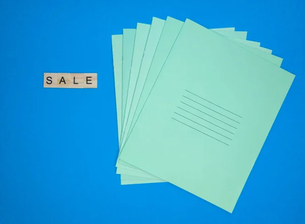 На синем фоне - надпись деревянными буквами продажи, стопка блокнотов, копирайт. школа продаж концепции — стоковое фото