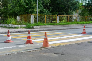 Yolun onarımı, yaya geçidinin etrafındaki turuncu koniler..