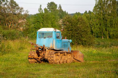 Kırsal tarım arazisi. Sovyet mavisi buldozer, dikiz manzaralı.