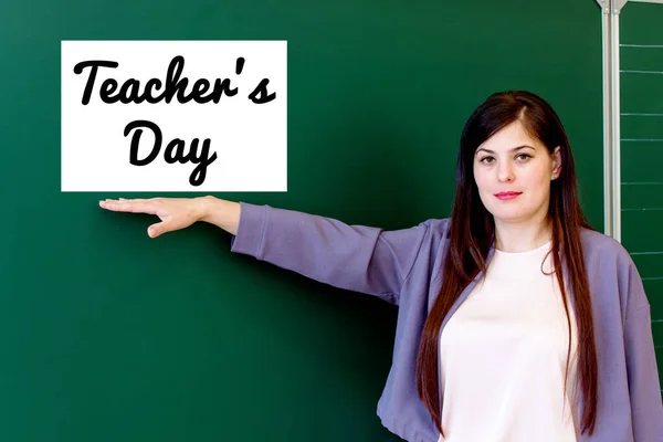 Una Maestra Para Pizarra Señala Con Mano Día Inscripción — Foto de Stock