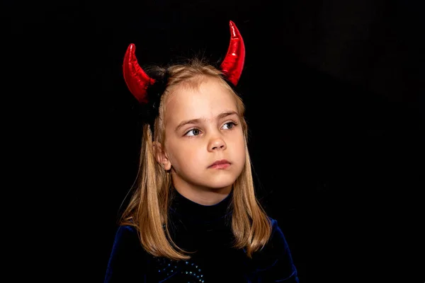 Siyah arka planda kırmızı boynuzları olan küçük bir şeytan. Cadılar Bayramı için kıyafet.