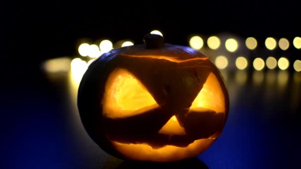 Orange Halloween pumpkin on dark background with bokeh — Stock Video