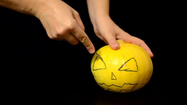 A woman carves a scary face in a pumpkin. Happy Halloween. — Stock Video