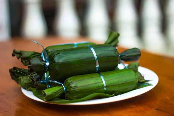 Ketupat Daun Pisang closeup çekim ahşap Tablo arka plan bulanıklık. Malezya mutfağı 