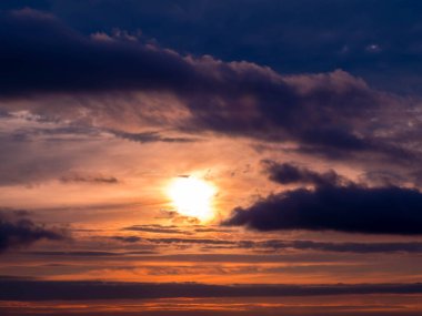 Resmedilmeye değer dramatik bir gün batımı bulutların arasından güneşle birlikte. Güneşin altın ışınları fırtına bulutlarını delip geçiyor. Barış ve mutluluk kavramı.