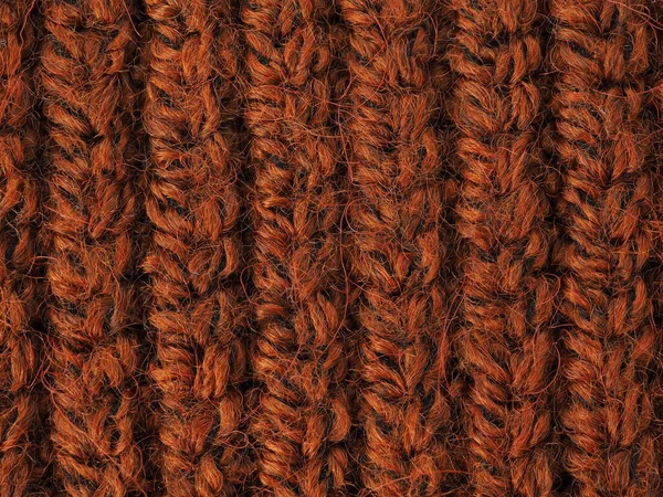 Un hermoso primer plano de un patrón de lana tejida a mano cálida y suave. Textura de un suéter marrón, calcetines o bufanda. fondo de material de punto naranja — Foto de Stock