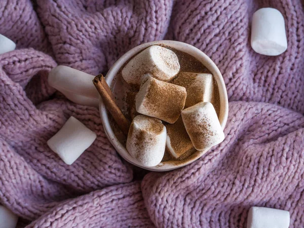 Gemütliche Stimmung Lifestile, Stillleben Konzept. Becher mit aromatischem Kakao, Pullover und Zimt auf rosa Strickpullovern als Hintergrund. Traditionelles Winter- oder Herbstheißgetränk zu Hause. Draufsicht, flache Lage, Nahaufnahme — Stockfoto