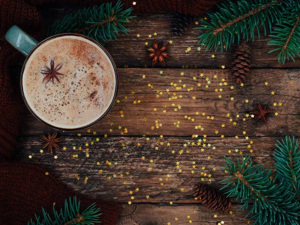 Tarjeta de vacaciones para el nuevo año es 2021 en colores cálidos y de moda. Composición navideña de abeto, taza de café, conos, anís, suéter acogedor y estrellas confeti sobre fondo rústico de madera. Piso tendido, vista superior — Foto de Stock