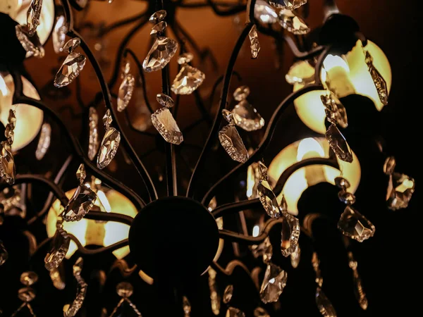 Detaljer om Viktoriansk stil ljuskrona. Suddiga gnistrande kristall hängen och runda facetterade kristaller hängen närbild på suddig bakgrund. Mjukt fokus på detaljer av lyx glas kristalllampa — Stockfoto