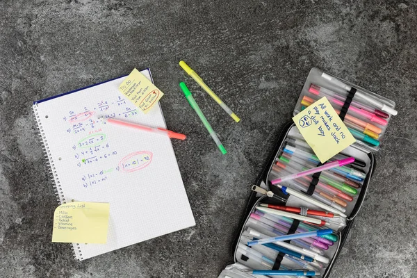 Matematik kitabı aritmetik problemleri ve kalem kutusu ile elle yazılmış, liste yapmak için, mermer tablo