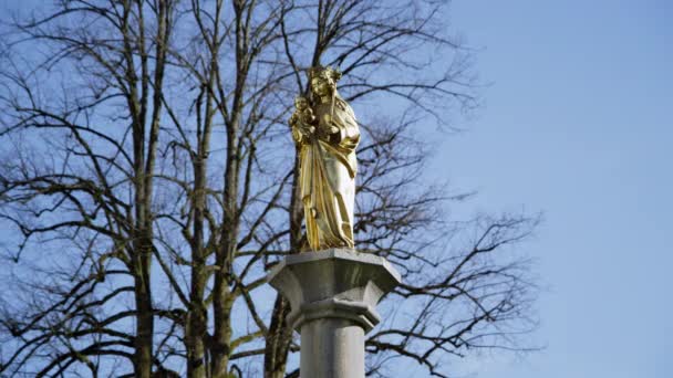 Золотая Статуя Мария Младенцем Иисусом Сером Бетонном Основании Перед Голым — стоковое видео