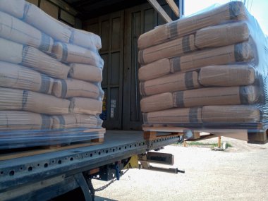Krasnodar, Rusya - 13 Haziran 2019: Forklift kullanan bir kamyondan çimento torbaları indiriliyor.