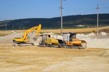 Taman, Rusya - 9 Temmuz 2019: Yolun inşaatı üzerine kazı. İnşaat için ağır makineler.