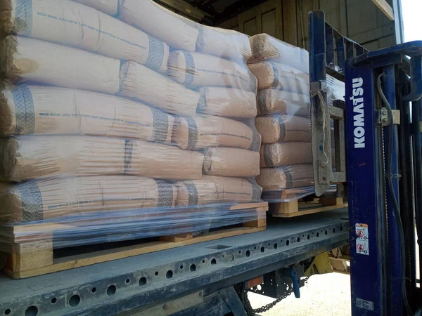 Krasnodar, Rusya - 13 Haziran 2019: Forklift kullanan bir kamyondan çimento torbaları indiriliyor.