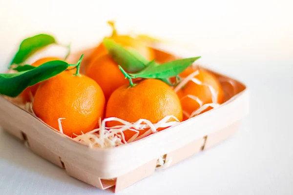 Tangerines with green leaves in a basket Stock Picture