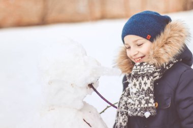  Bir çocuk bir kardan adam sculpts.