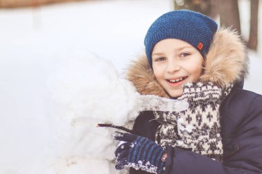  Bir çocuk bir kardan adam sculpts.