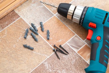 Elektrikli matkap ve ahşap zemin üzerinde yaptı çivi kapatın. Plastik zemin Süpürgelik montajı.