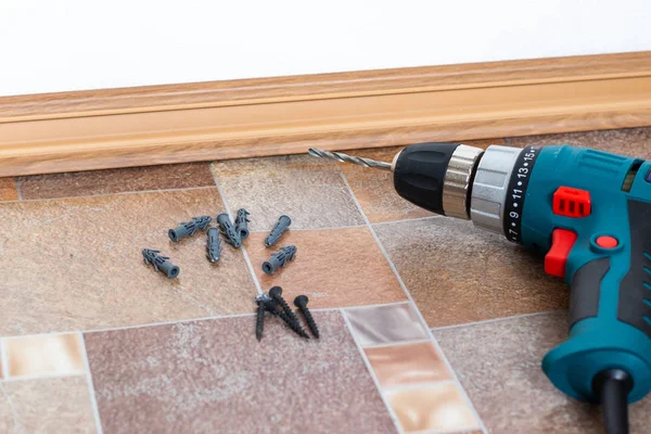 Installation of plastic floor plinth. Interior details.