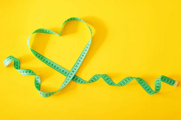 Hjärtformade mått band på gul bakgrund — Stockfoto