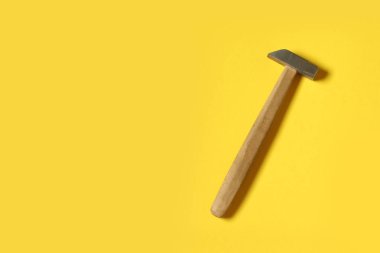 Sarı bir arka plan üzerinde demir çekiç. İş aleti tamir için.