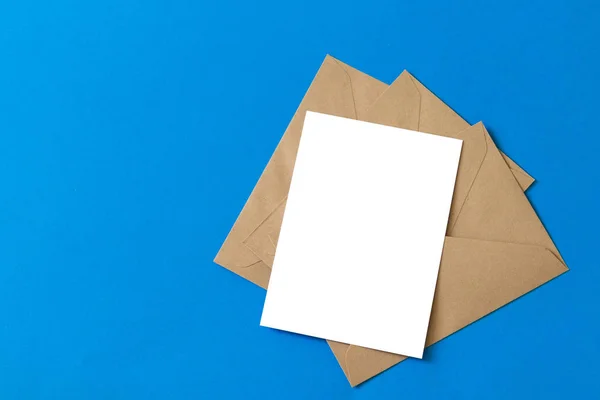 Cartão branco em branco com modelo de envelope de papel marrom kraft mock up — Fotografia de Stock