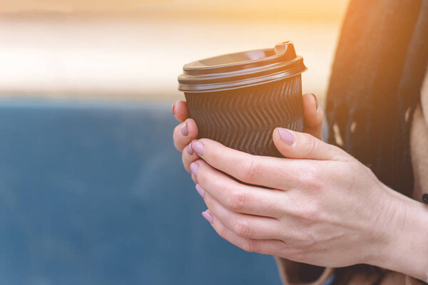 female hand holding a blank paper cup