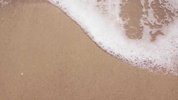 Onda marina da vicino. Acqua mare onda sabbiosa. Spiaggia di sabbia gialla e mare limpido oceano al mattino . — Video Stock