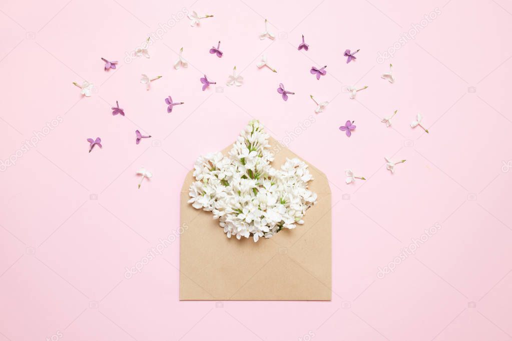 Flowers of purple lilac with blank paper on table. Rustic style.